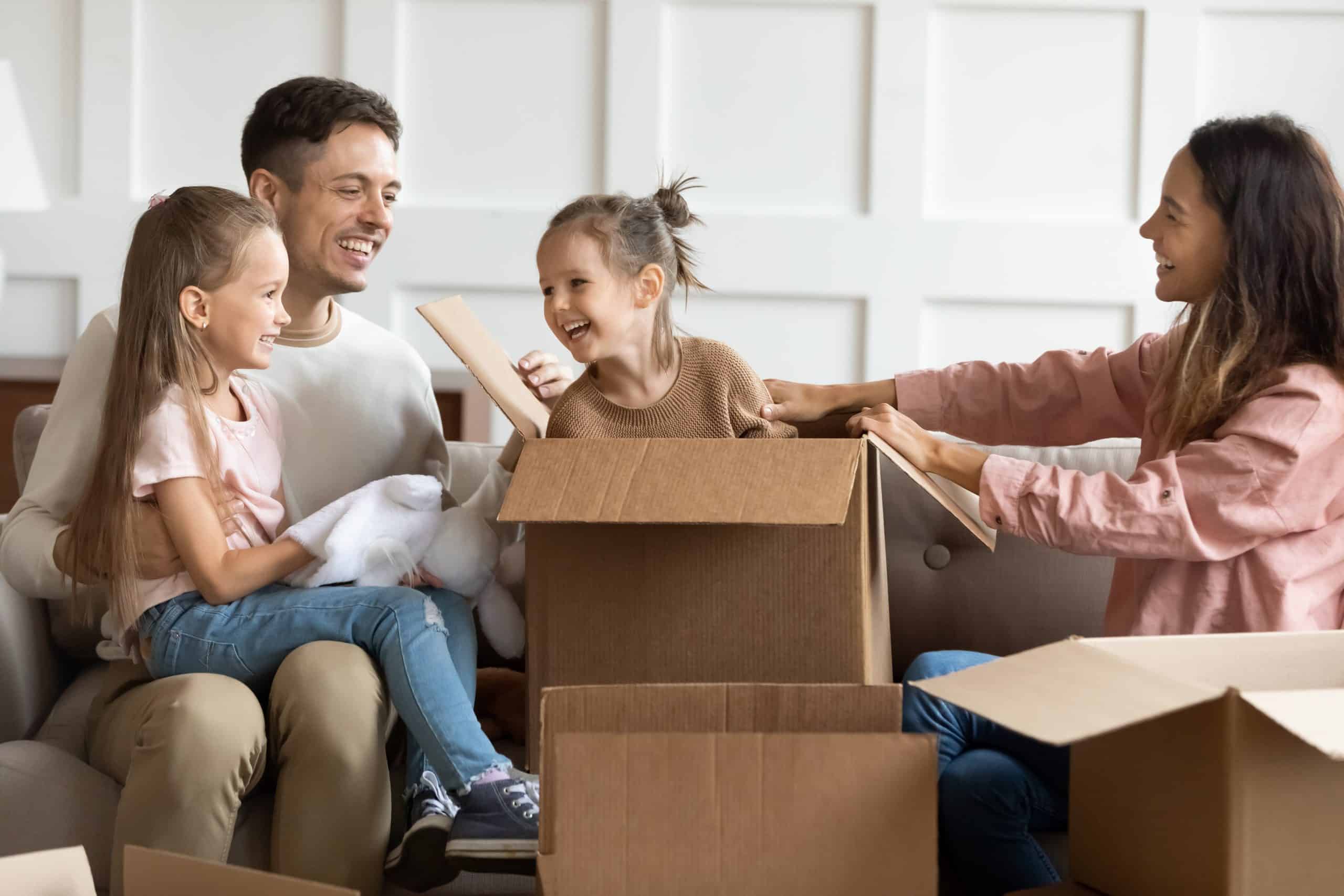 Family with two kids playing in moving boxes
